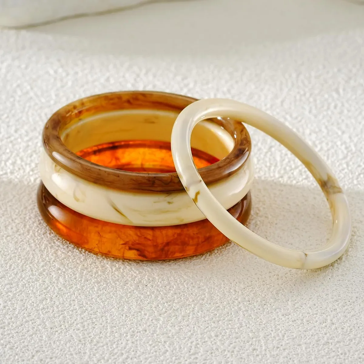 Two chunky resin bangles from the set worn on their own
