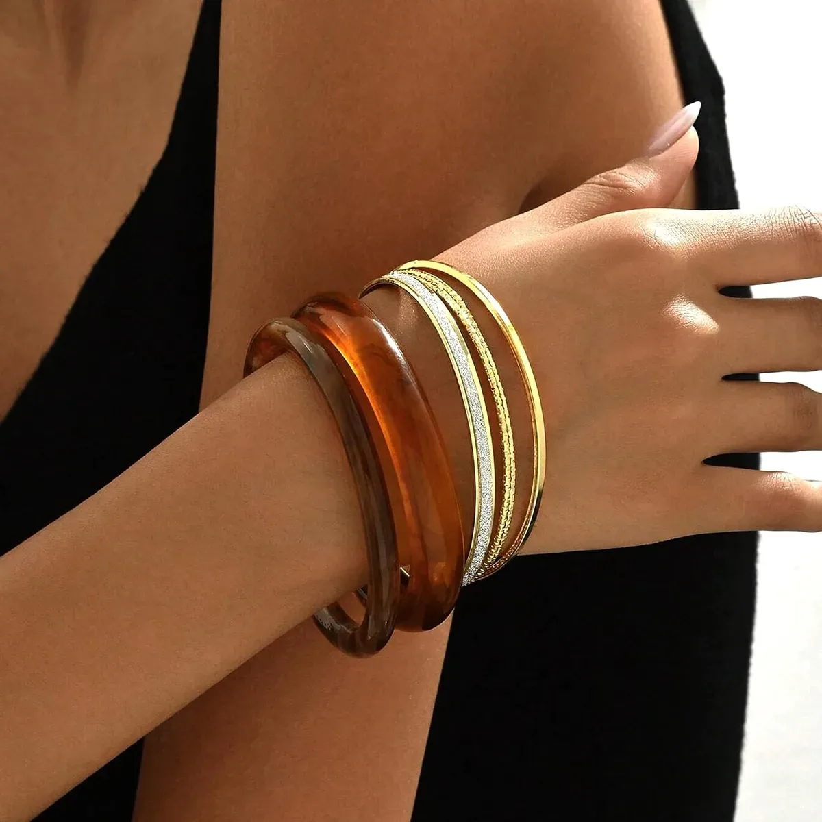 Chunky resin bangles styled with a cozy knit sweater sleeve