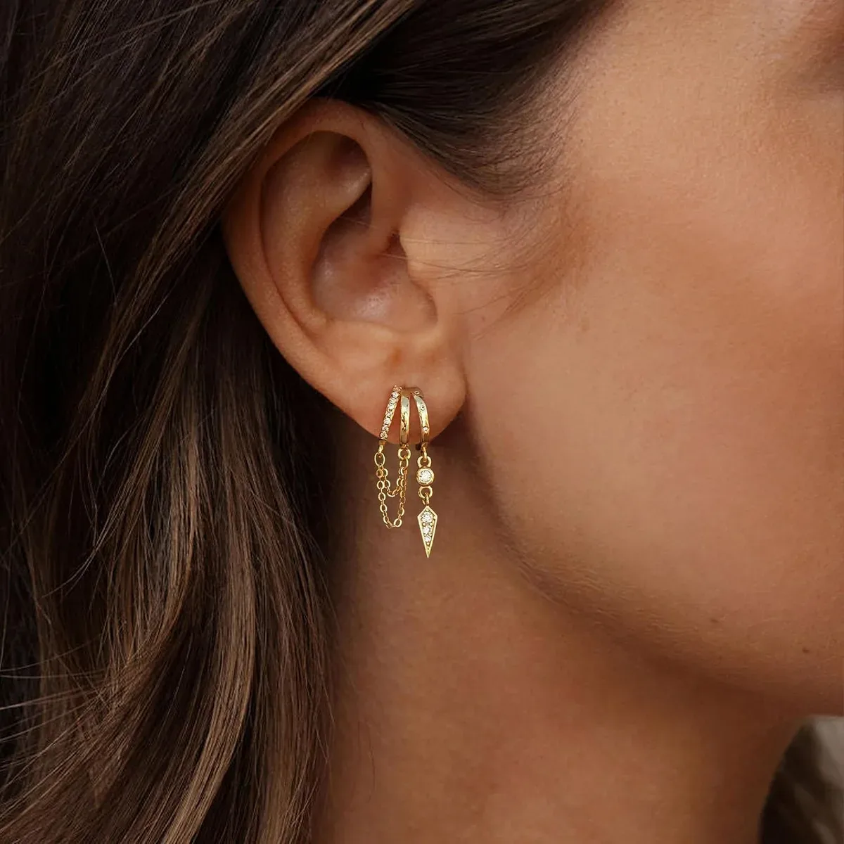 Gold dangle huggie earrings worn with casual daytime clothes