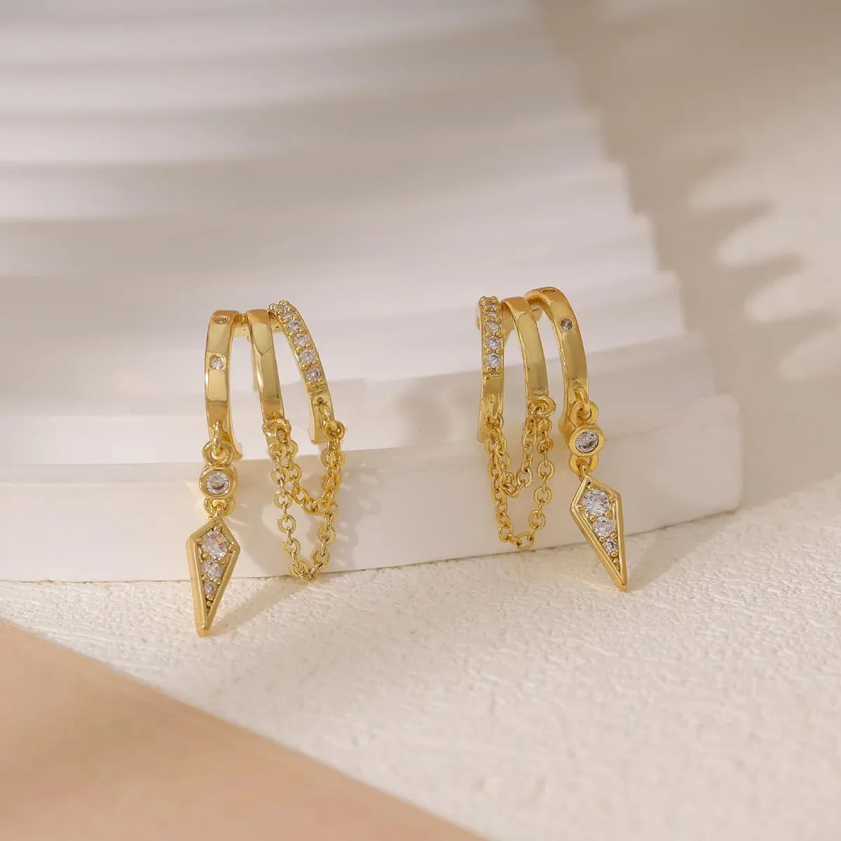 Close-up of the 14K gold plating on gold dangle huggie earrings