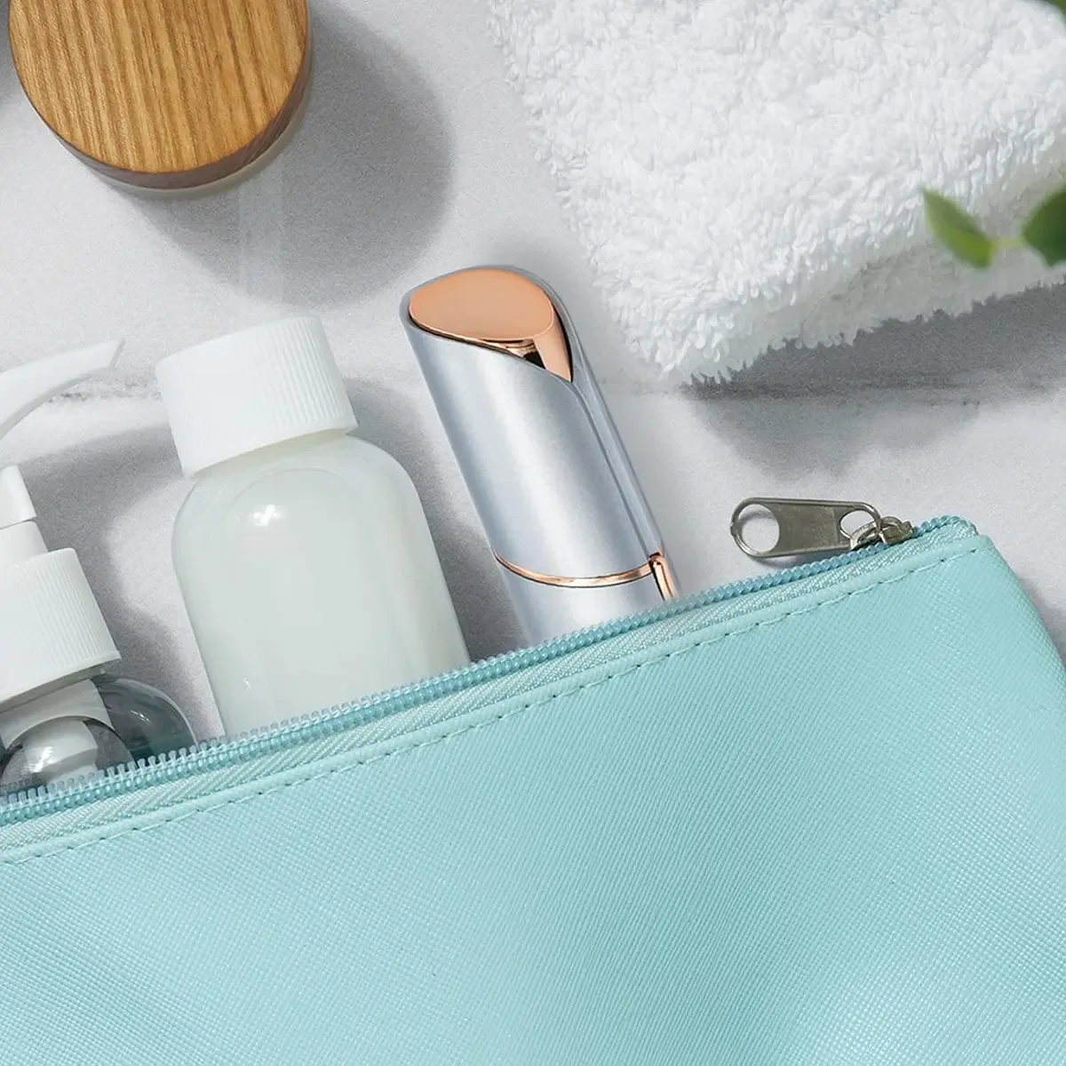 Lipstick-size facial hair remover tucked into a makeup bag