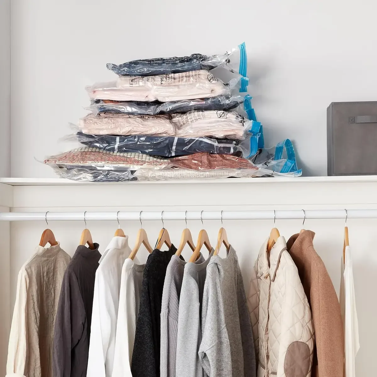 Compressed vacuum storage bags stacked above hanging clothes