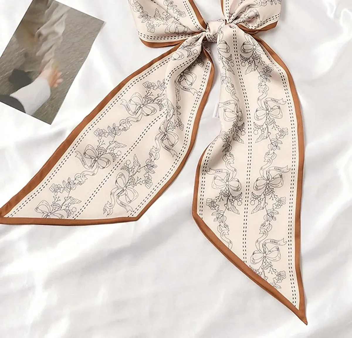 Skinny satin scarf knotted into a bow as a styling idea