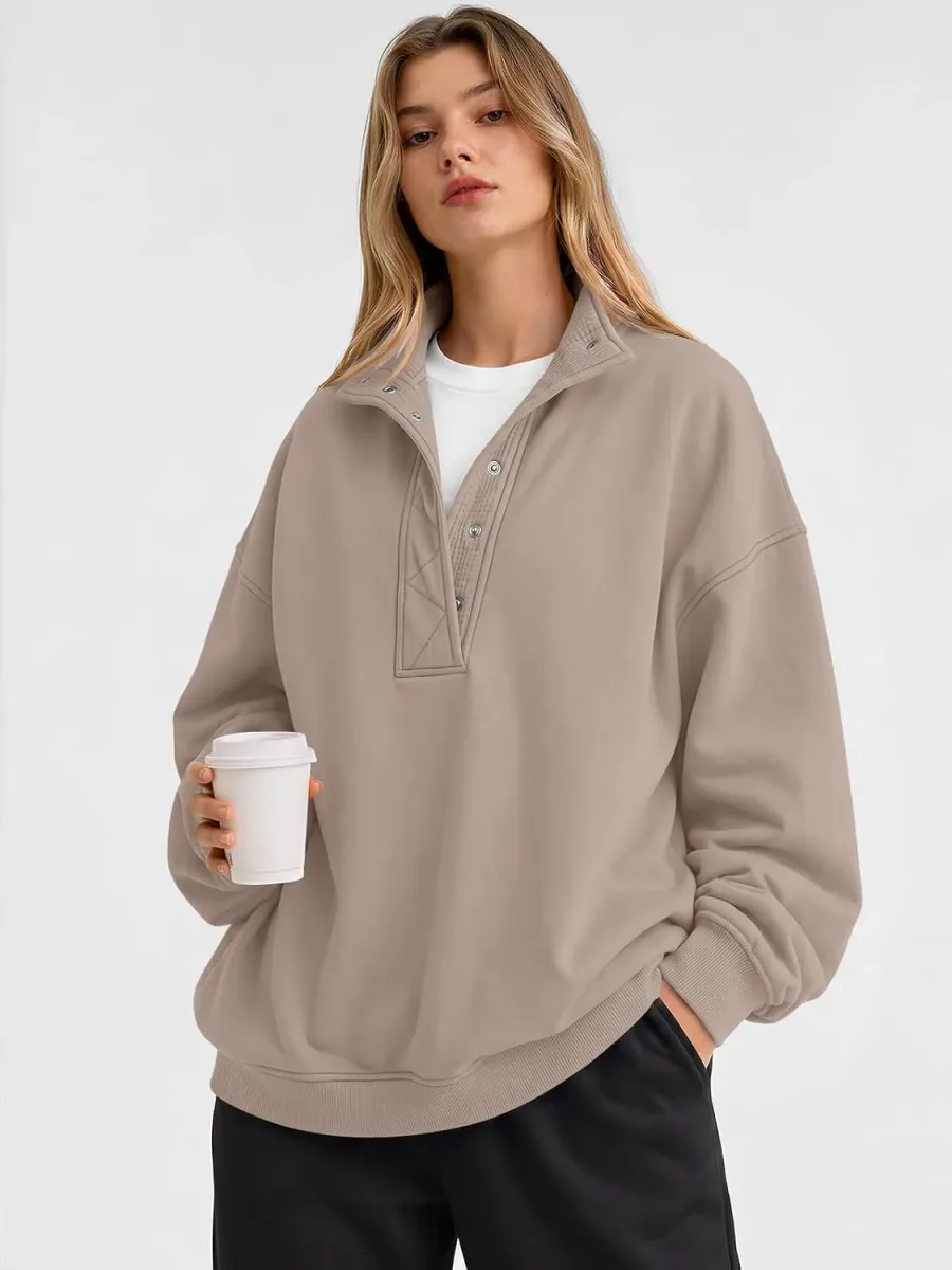 Woman holding a coffee cup in an oversized henley sweatshirt